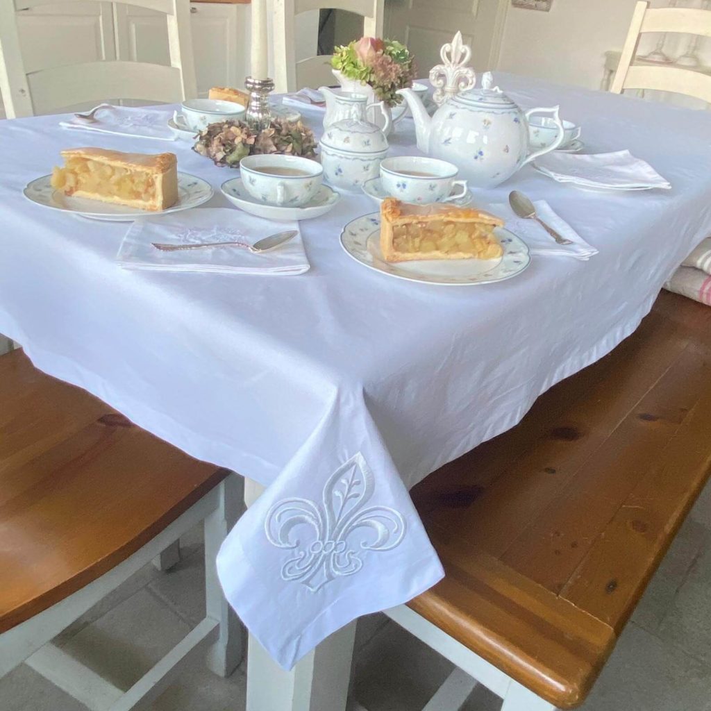gedeckter Tisch mit Tischdecke
weiße Tischdecke mit Stickerei Fleur de Lys