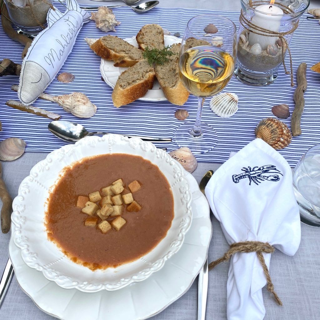 Fischsuppe mit Crourons und maritimer Deko Streifen Muscheln und Wein